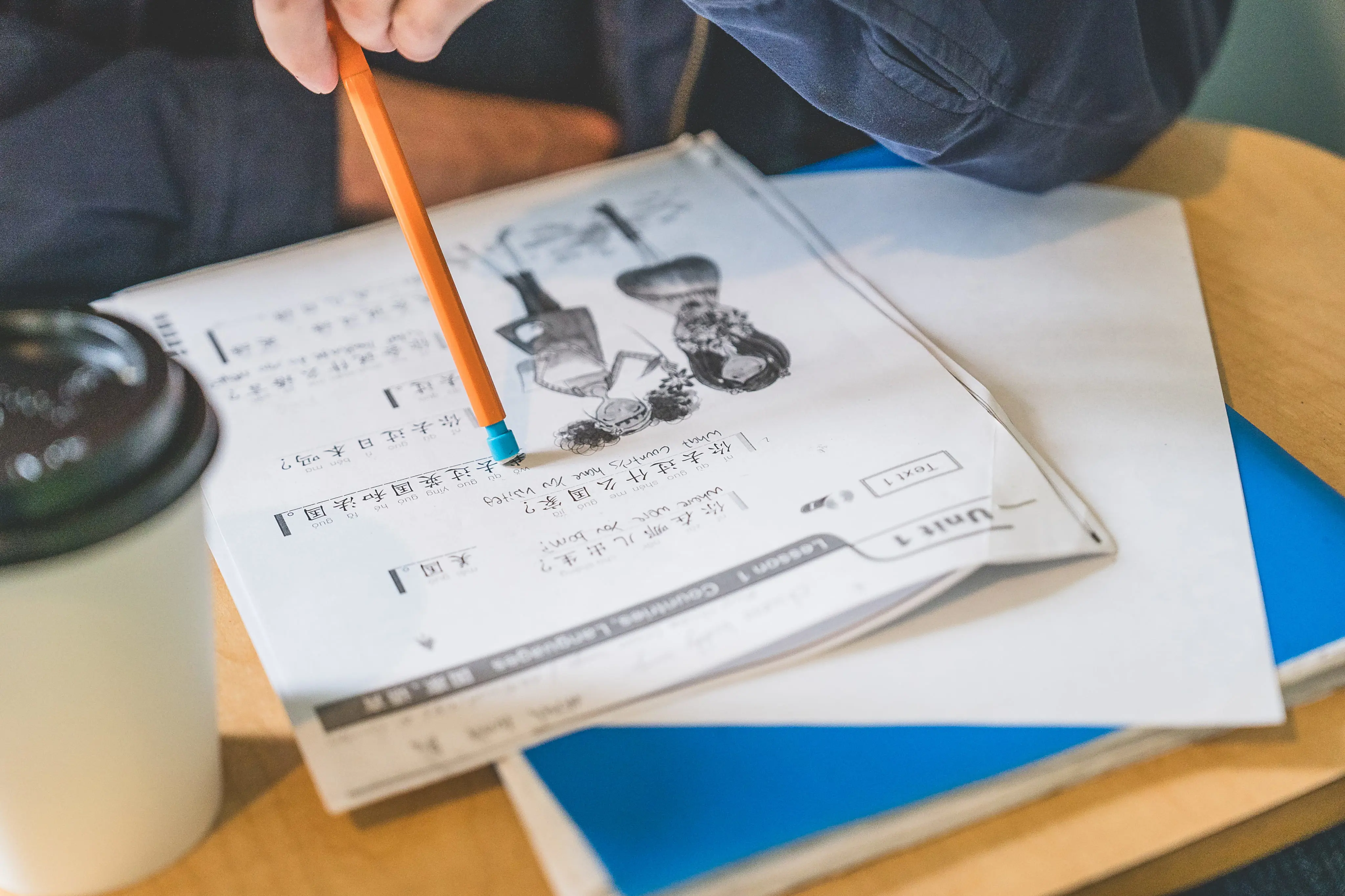 student working on a Japanese language worksheet during class, using a pencil to complete written exercises.
