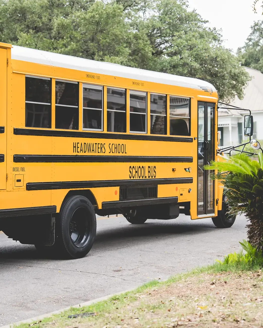 yellow Headwaters School bus parked outside a campus building.