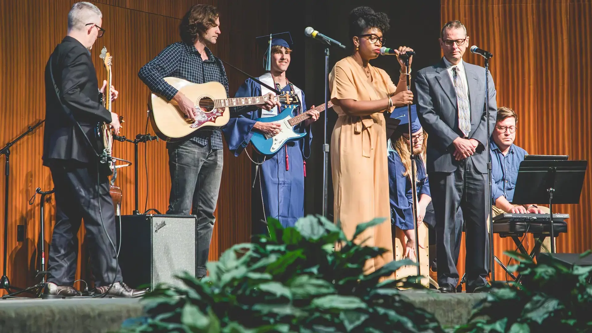 musicians and speakers performing on stage during a Headwaters School event.