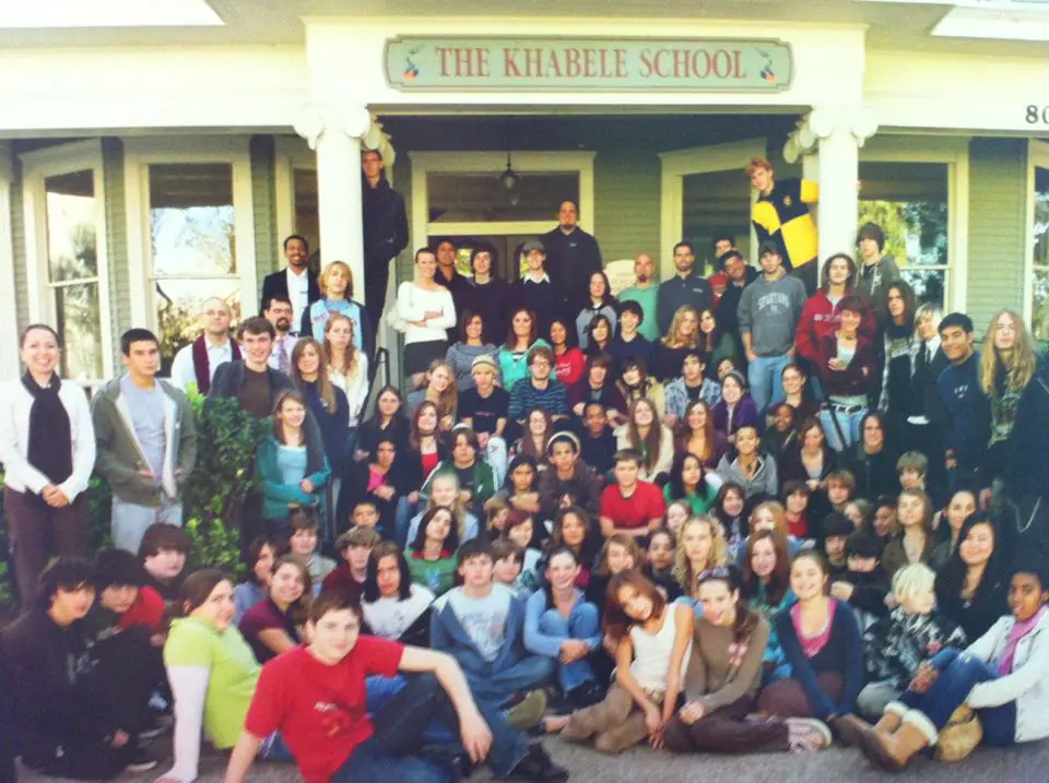 Group of students and staff gathered on the steps outside The Khabele School building, early 2000s.