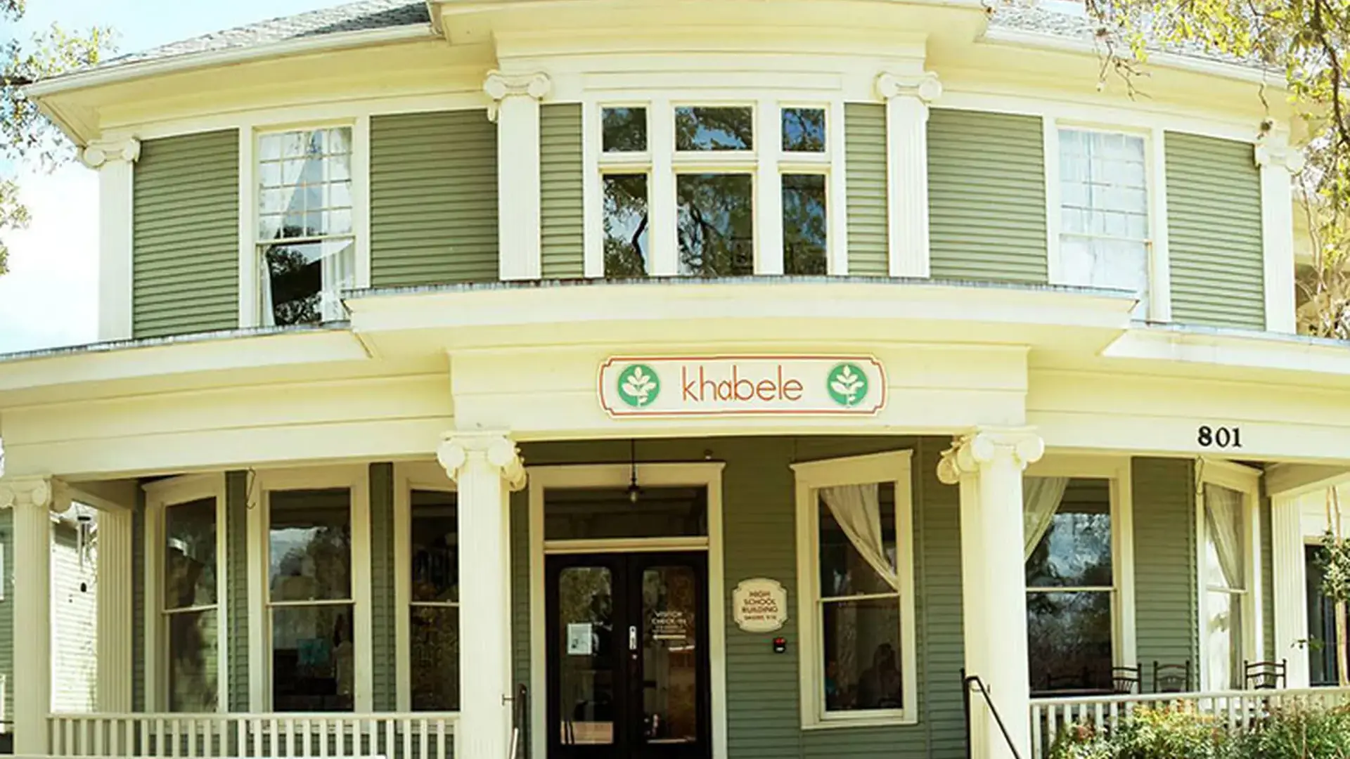 Exterior of the historic Khabele school building with a covered front porch.