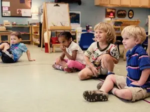 Primary students sit on the floor at circle time on the Primavera Campus.