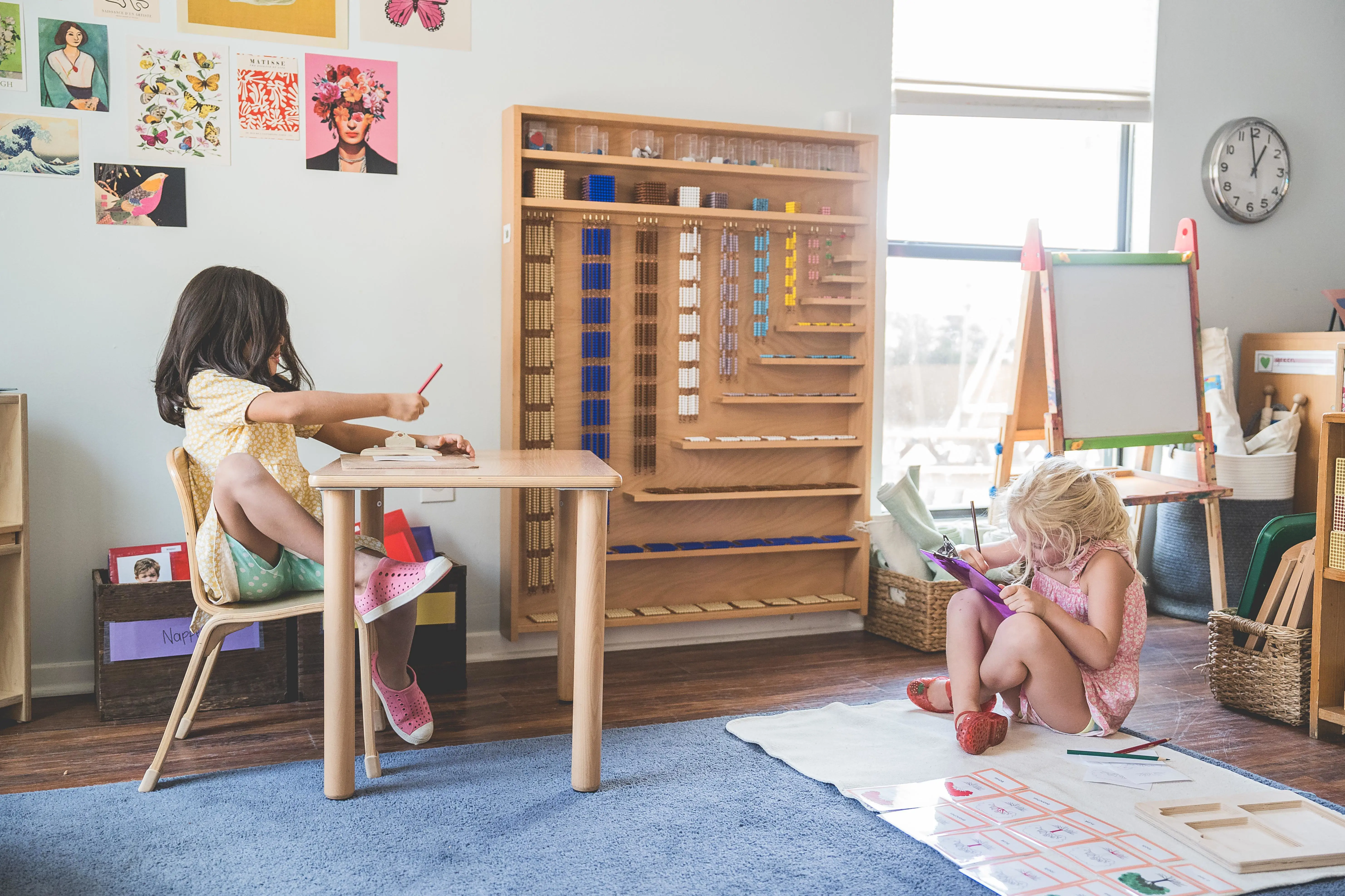 Two primary students work independantly in the Montessori classroom.