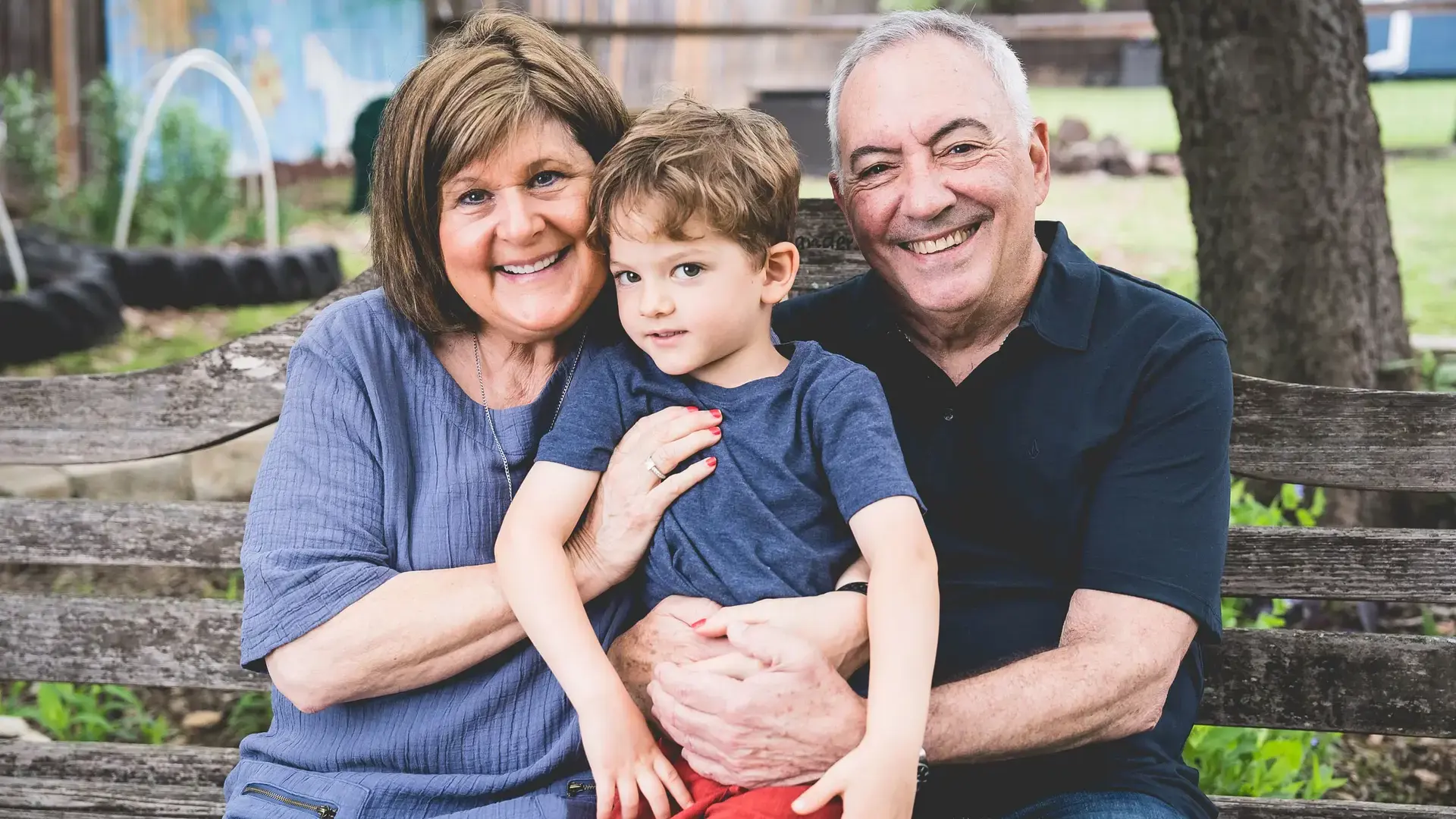 grandparent holding a young child outdoors.