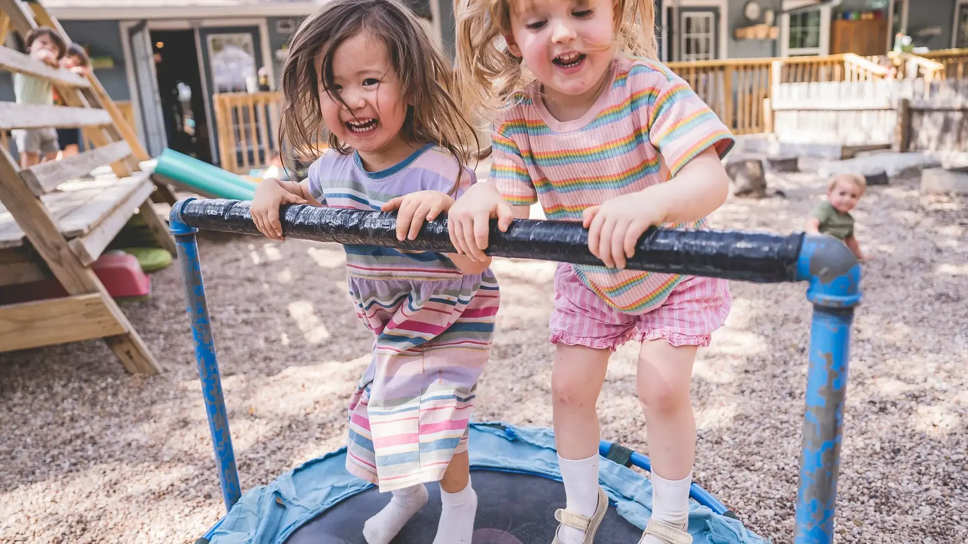 Young children playing together on outdoor playground equipment.