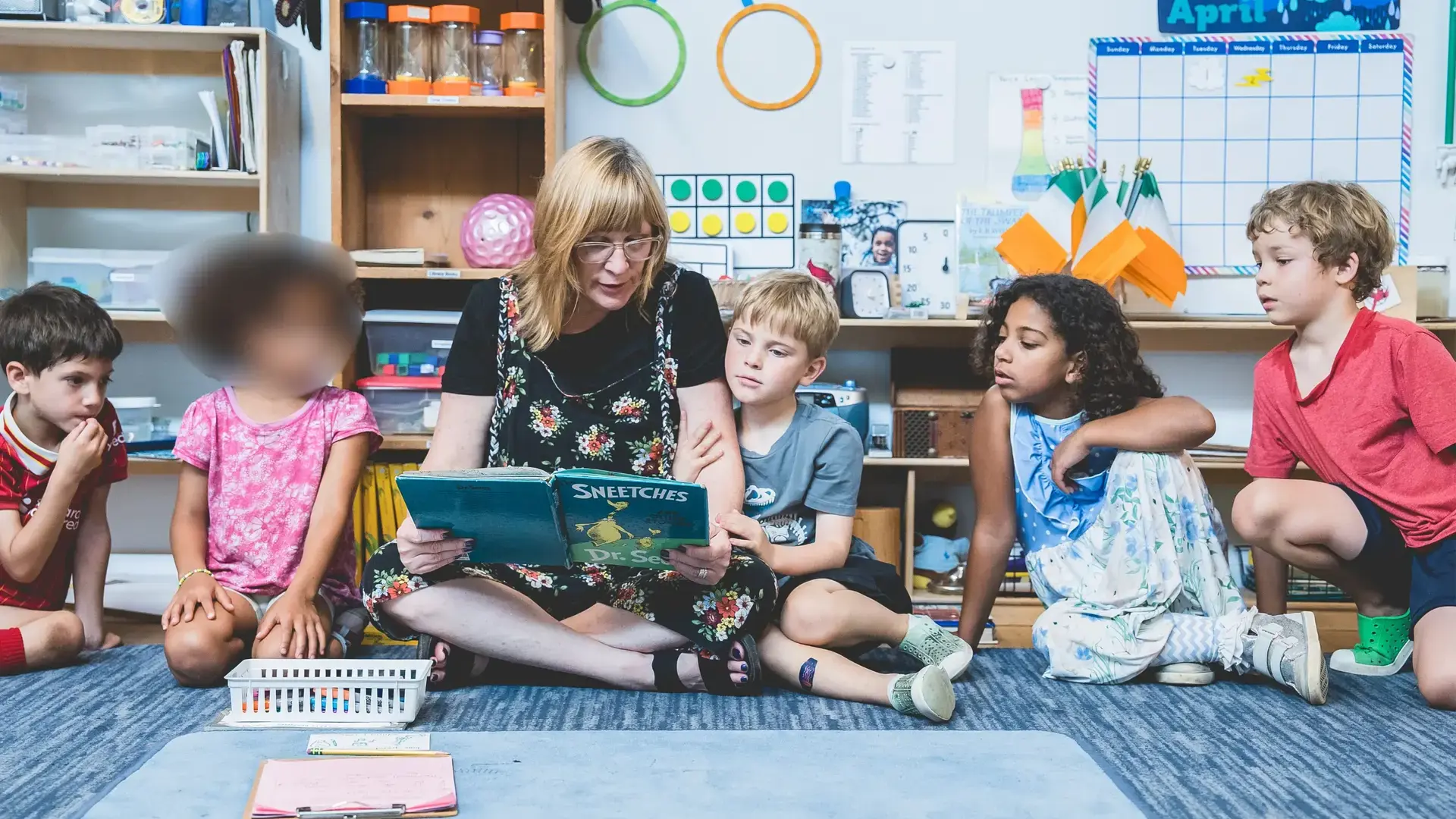 elementary guide reading with a small group of students in the classroom.