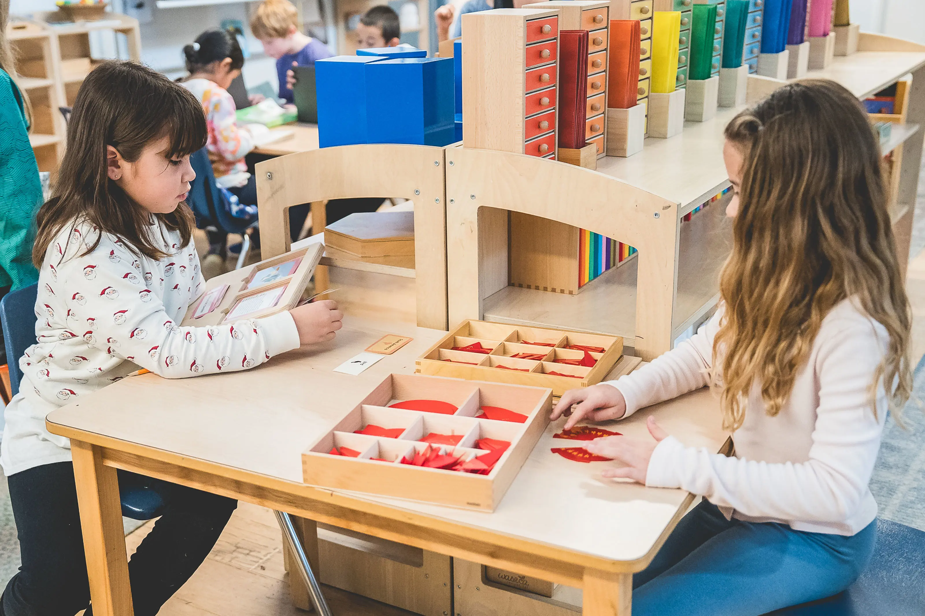 lementary students working with fraction materials at a table with a guide.