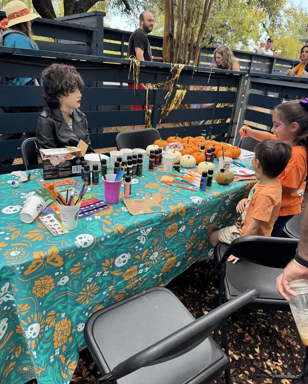 students sitting at a pumpkin-painting station during the Headwaters Fall Fest.