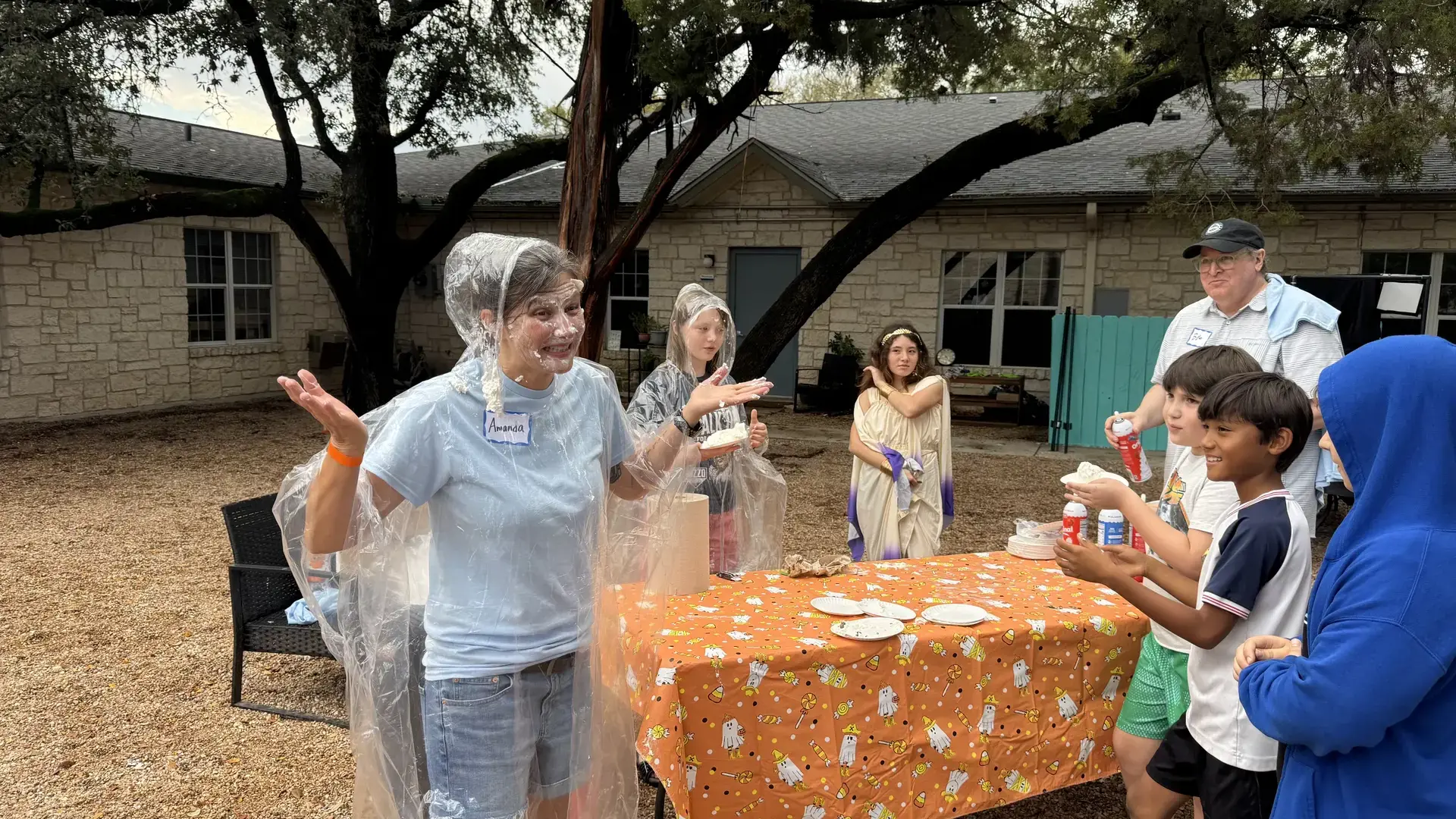 families gathered around a table for a pie-in-the-face game at the Headwaters Fall Fest.