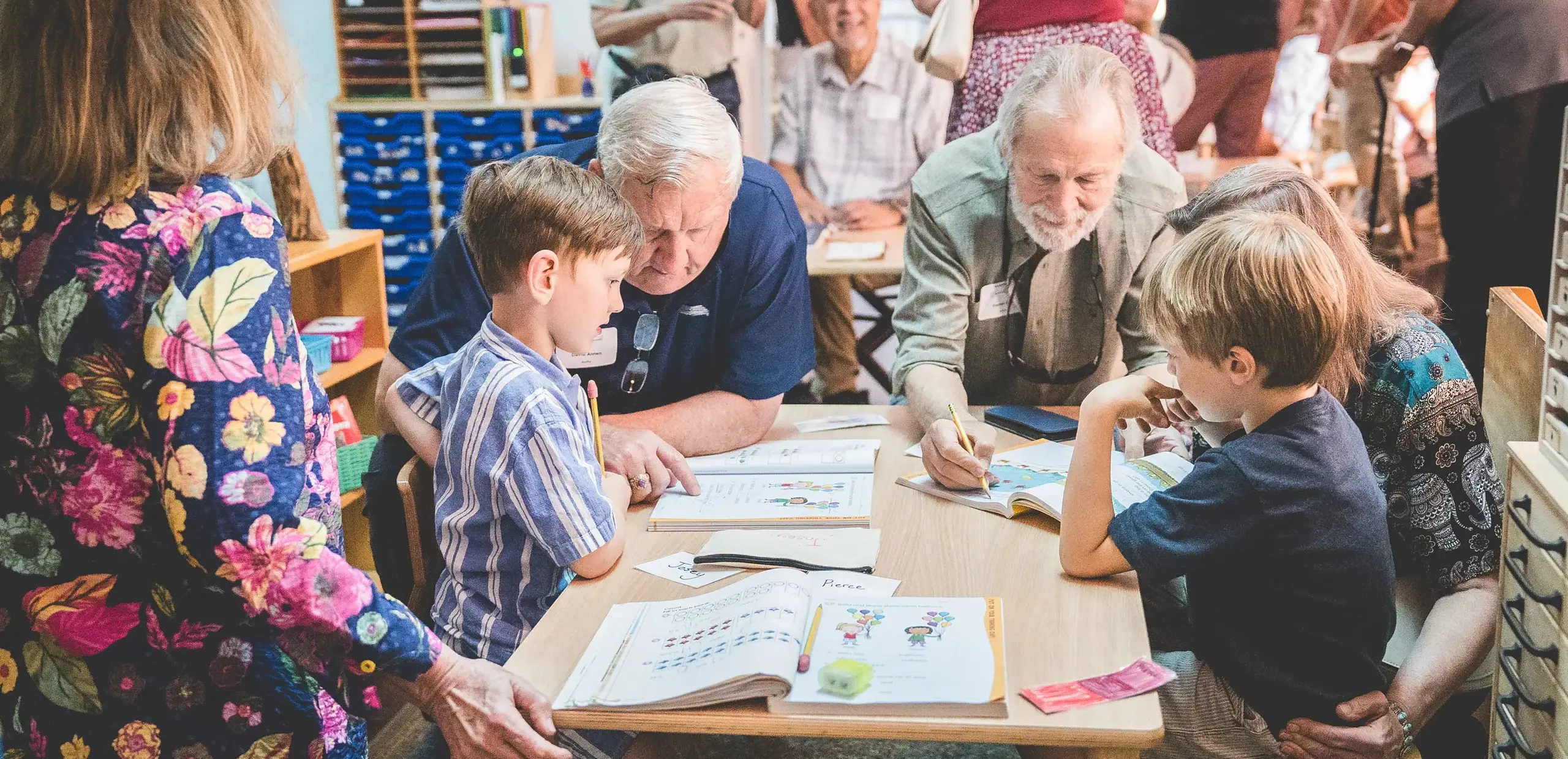 grandparents working through workbooks with elementary students in the classroom during Grandparents and Special Friends Day.