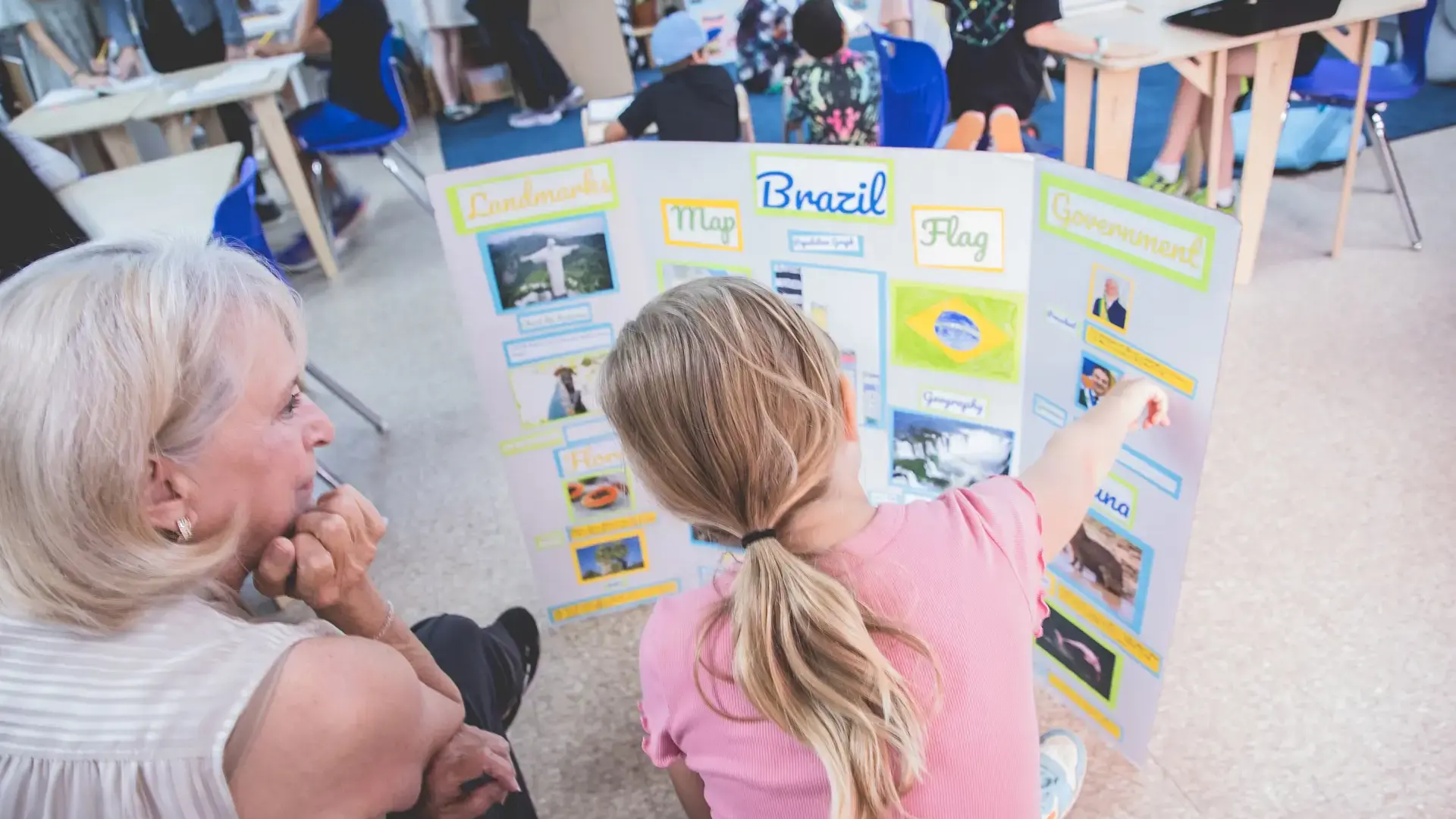 a grandmother looking at a student's project board during a presentation.