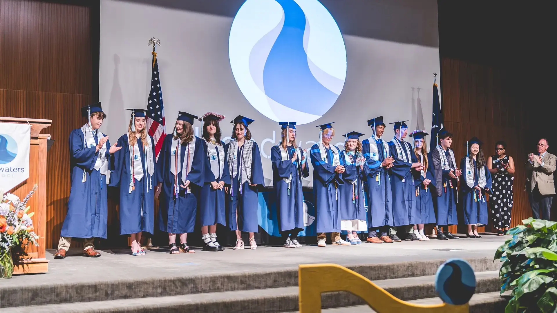 Headwaters High School graduates standing together in caps and gowns during commencement.