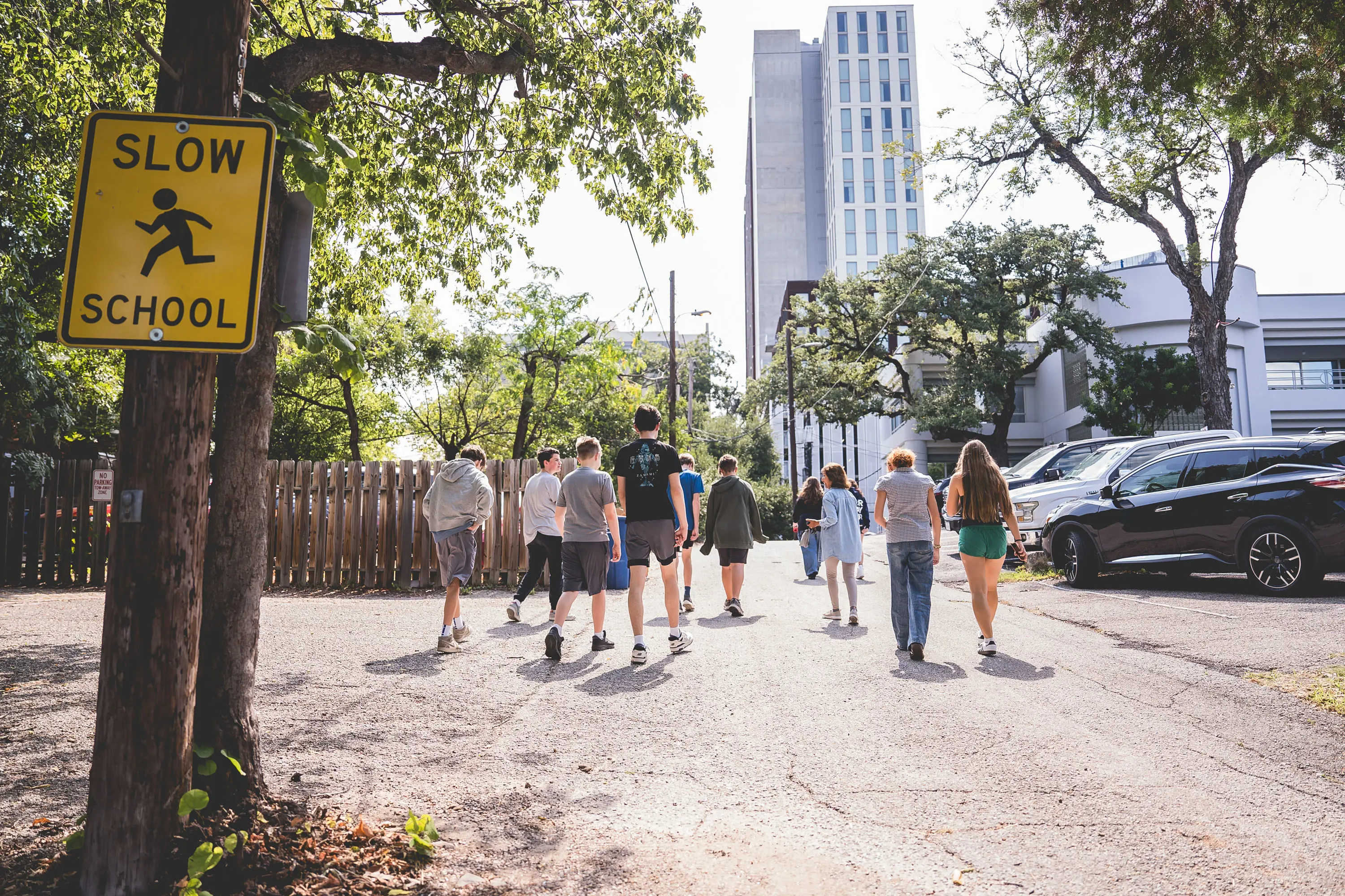 high school students walking down a street near a school sign during a City as Classroom activity.