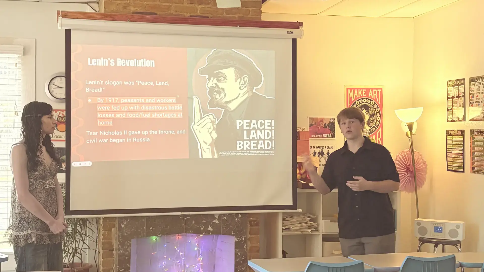 High school students engaged in a self-directed learning session with a presentation displayed on screen.