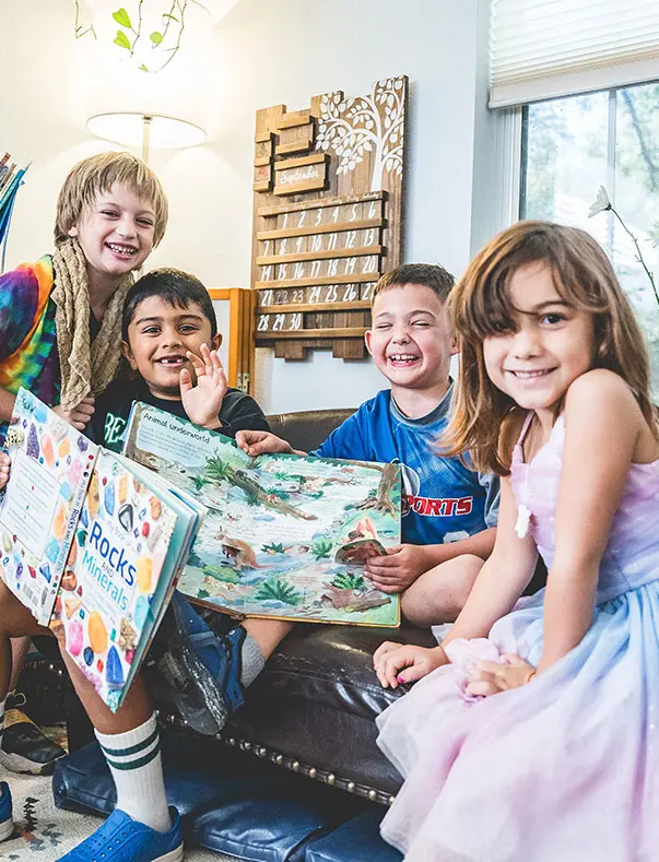 K-1 Students sit in the reading corner of the Montessori classroom enjoying a good book.