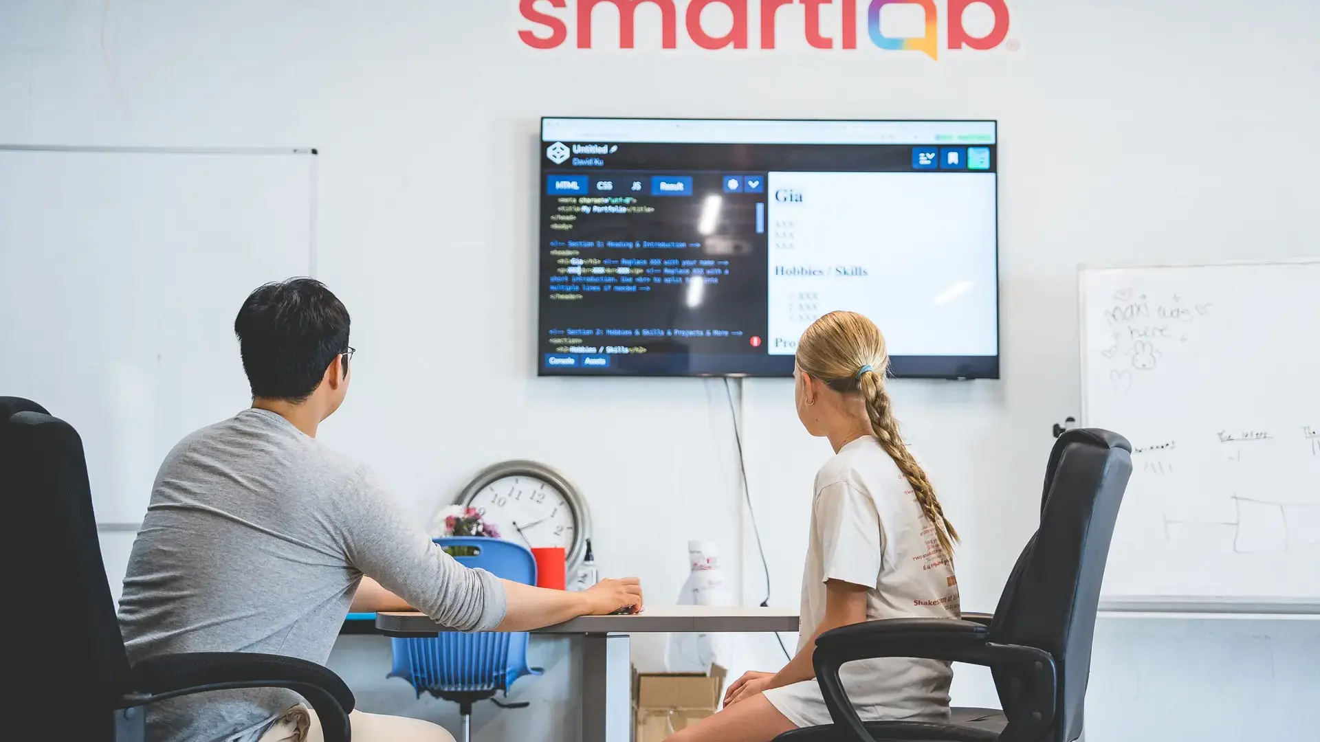 a teacher working with a student on a coding activity using a Smart Lab display.