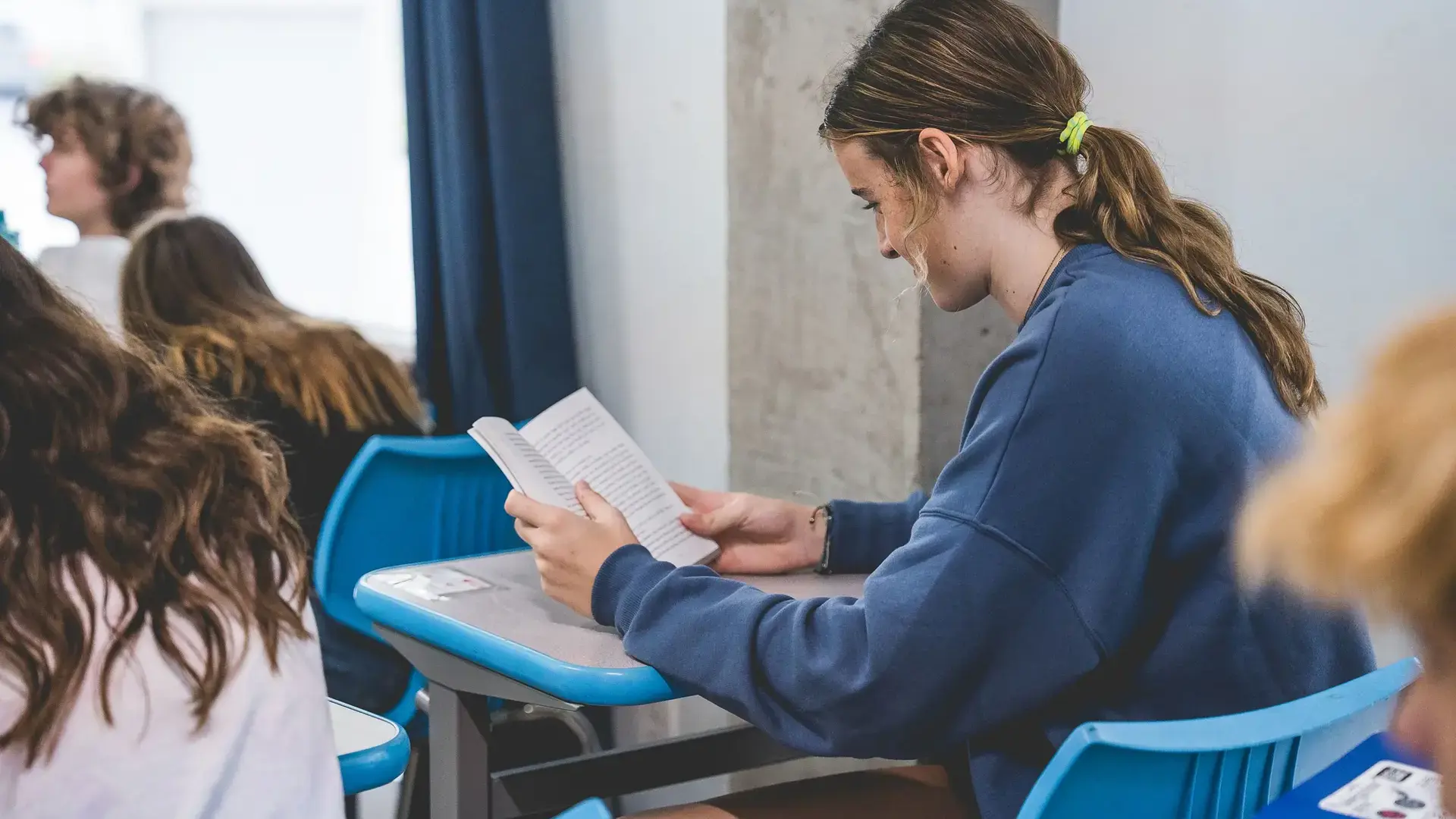 student reading a book in a class