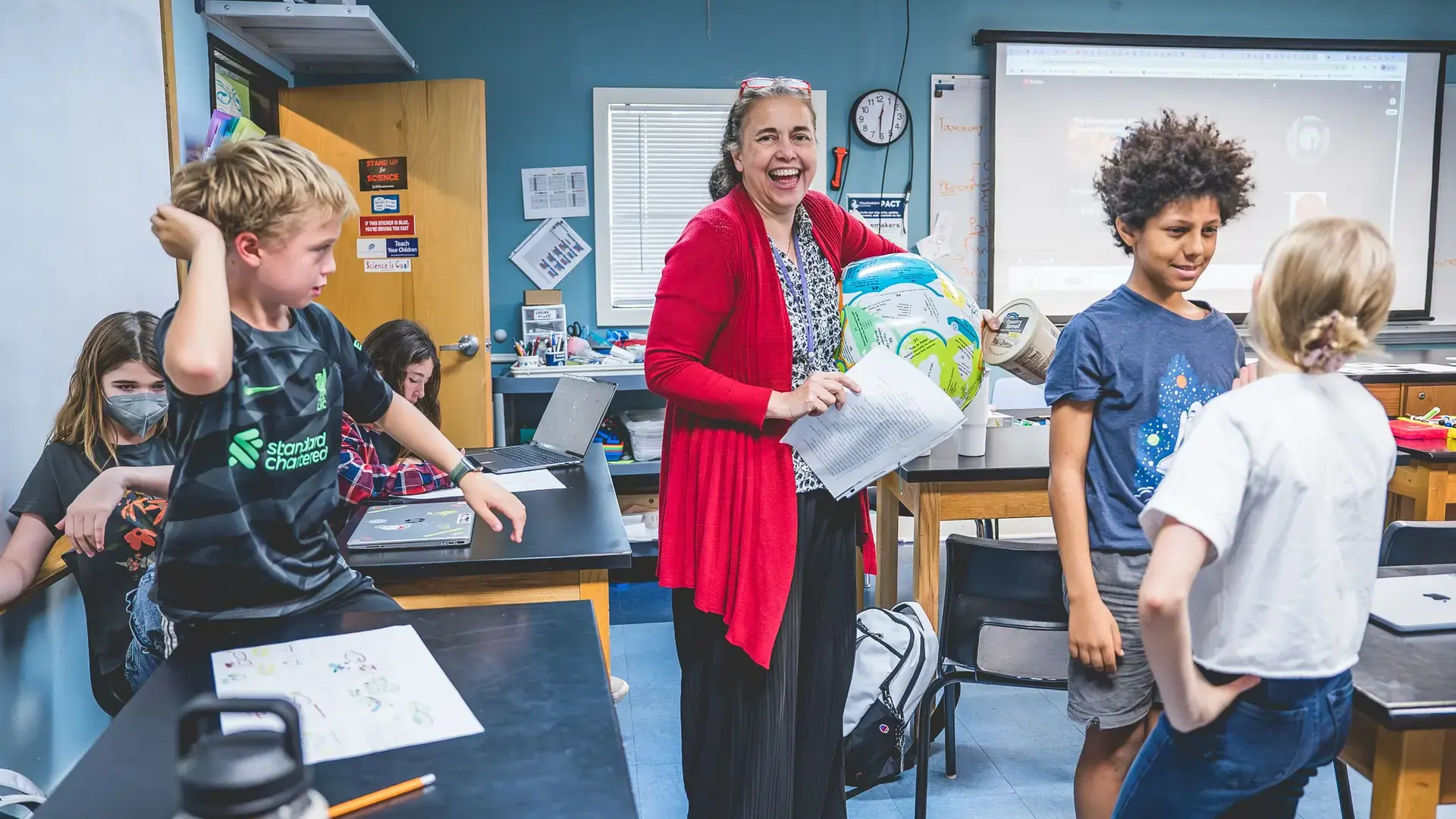 Middle school students participating in a hands-on science lesson with their teacher.