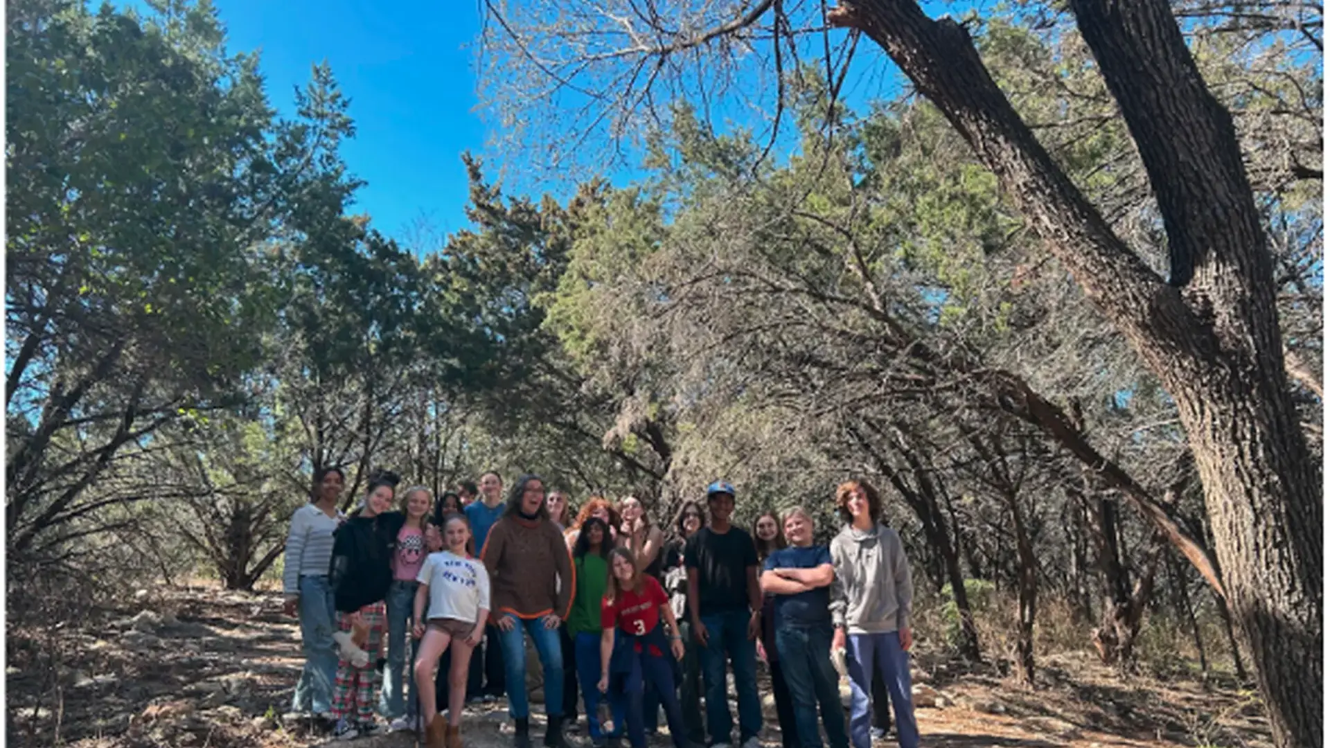 middle school students posing together outdoors during a greenbelt education trip.