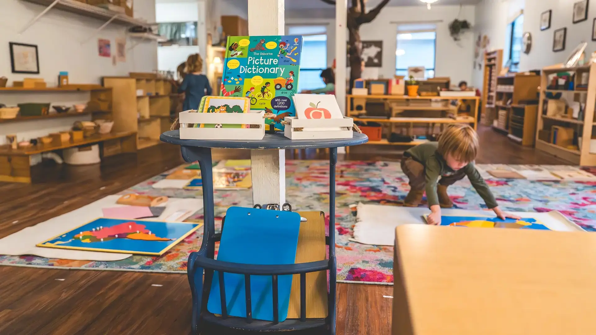 Montessori classroom with math materials arranged on a table and student workspace.