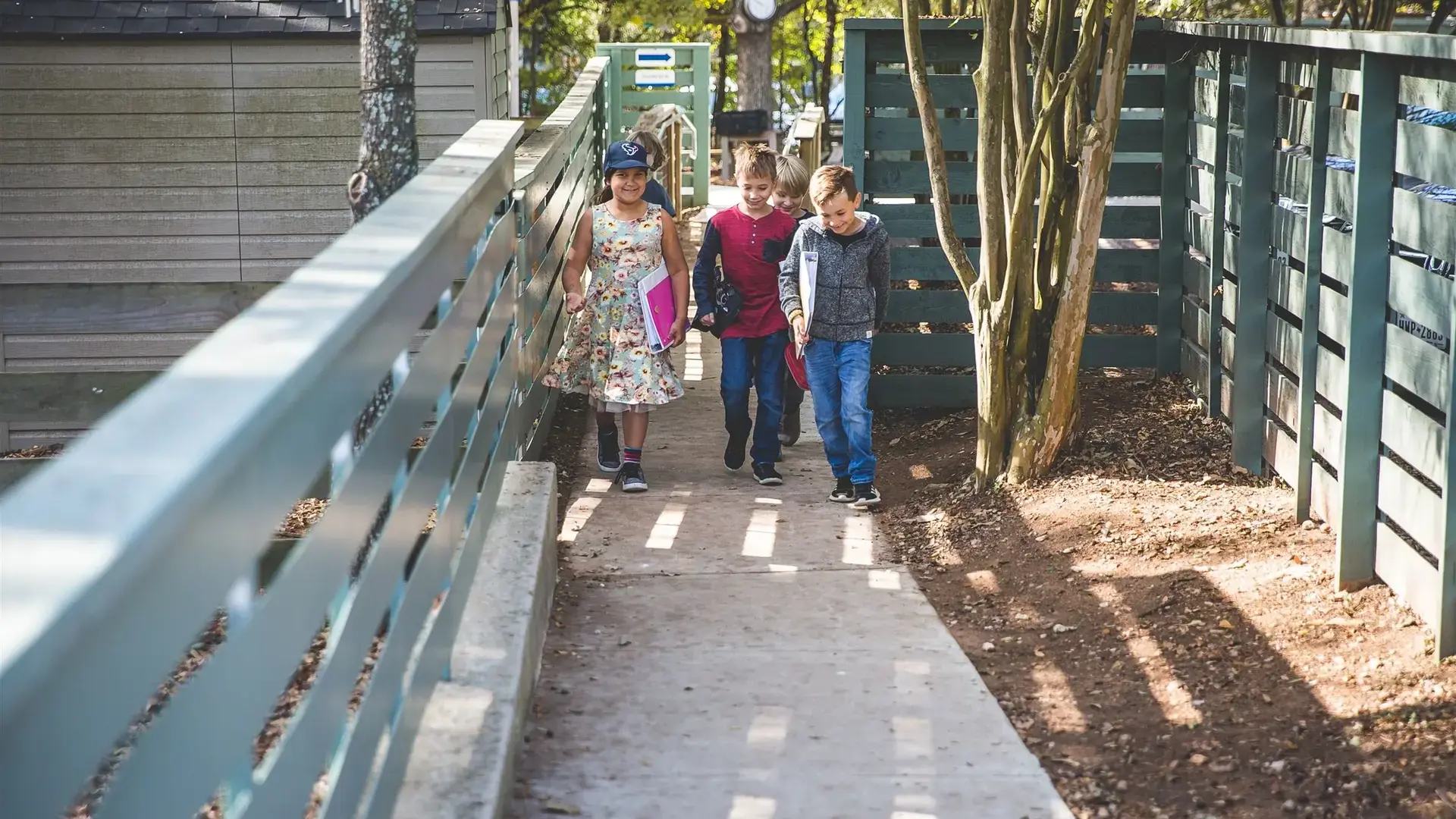 Students walking along an outdoor covered walkway at school.