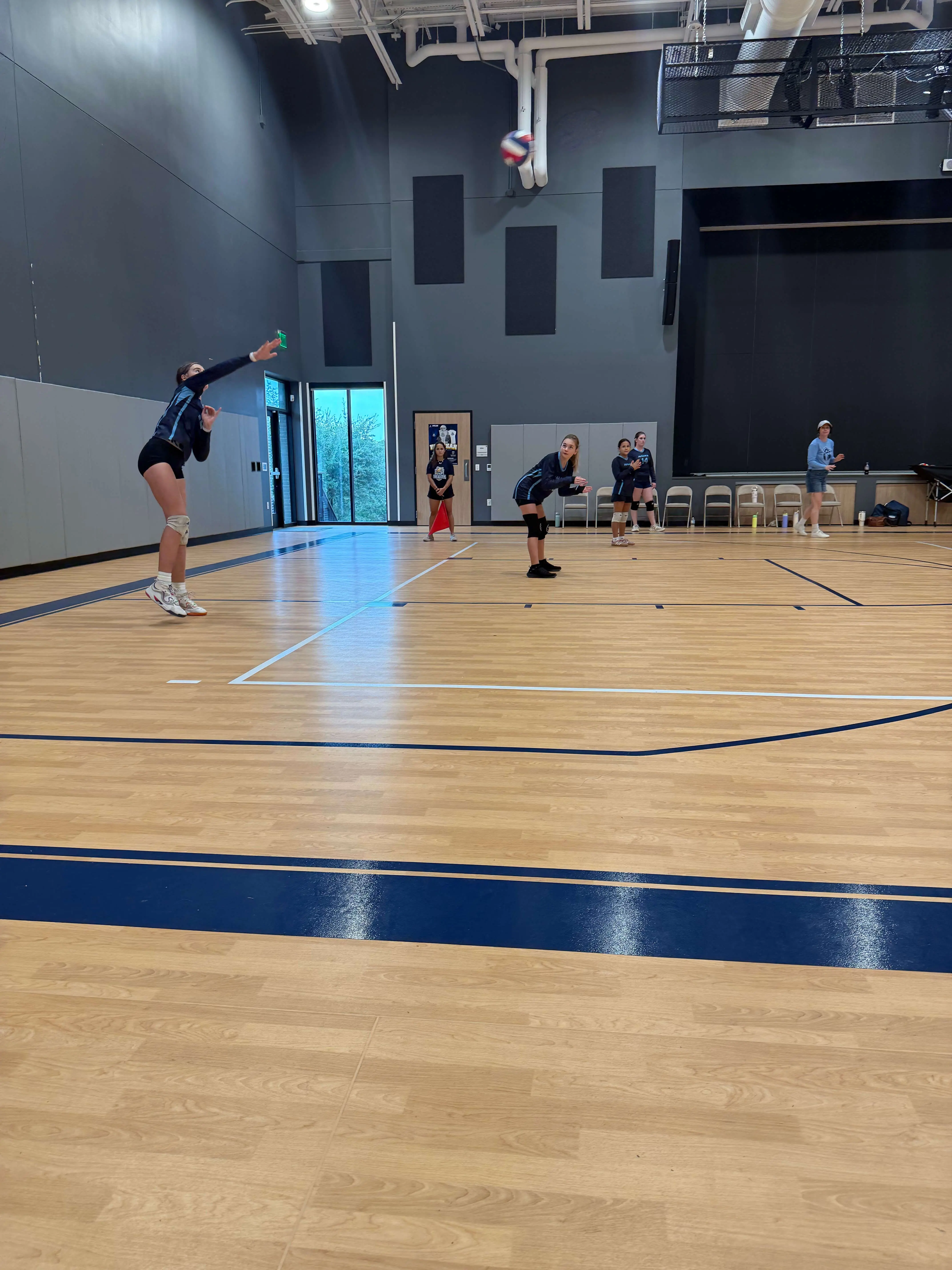 Headwaters middle school volleyball team competing during a game in the gym.