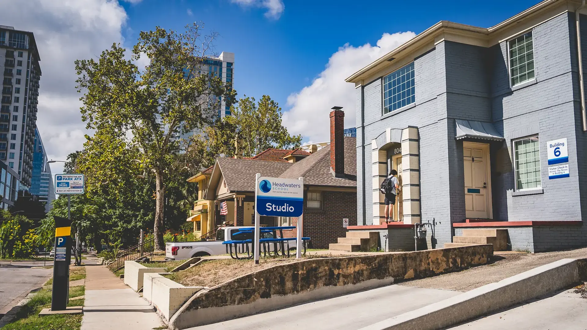 Street view of Headwaters School's River Campus buildings with downtown high-rises in the background.