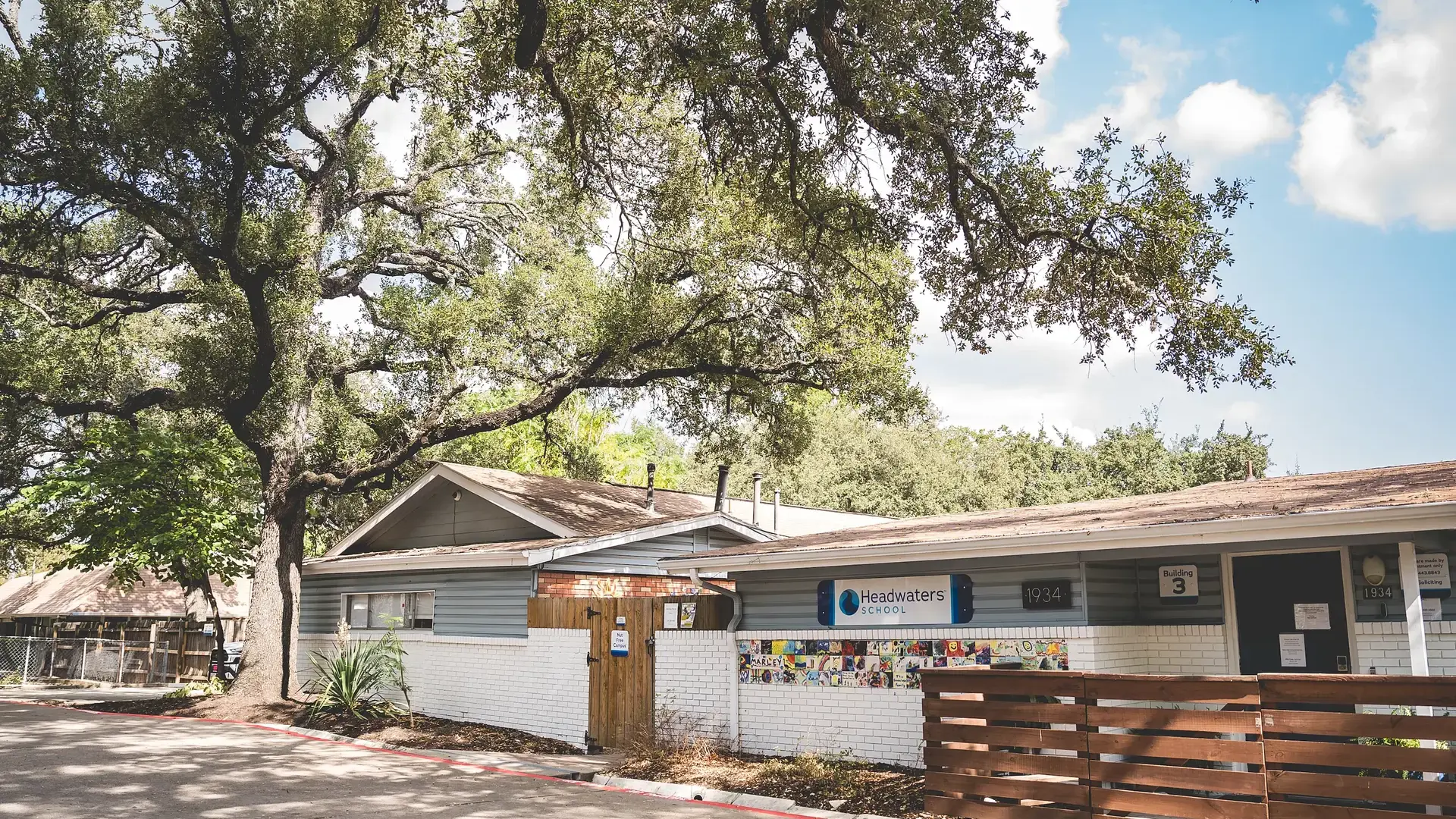 Exterior of the Springs Campus school building surrounded by trees.