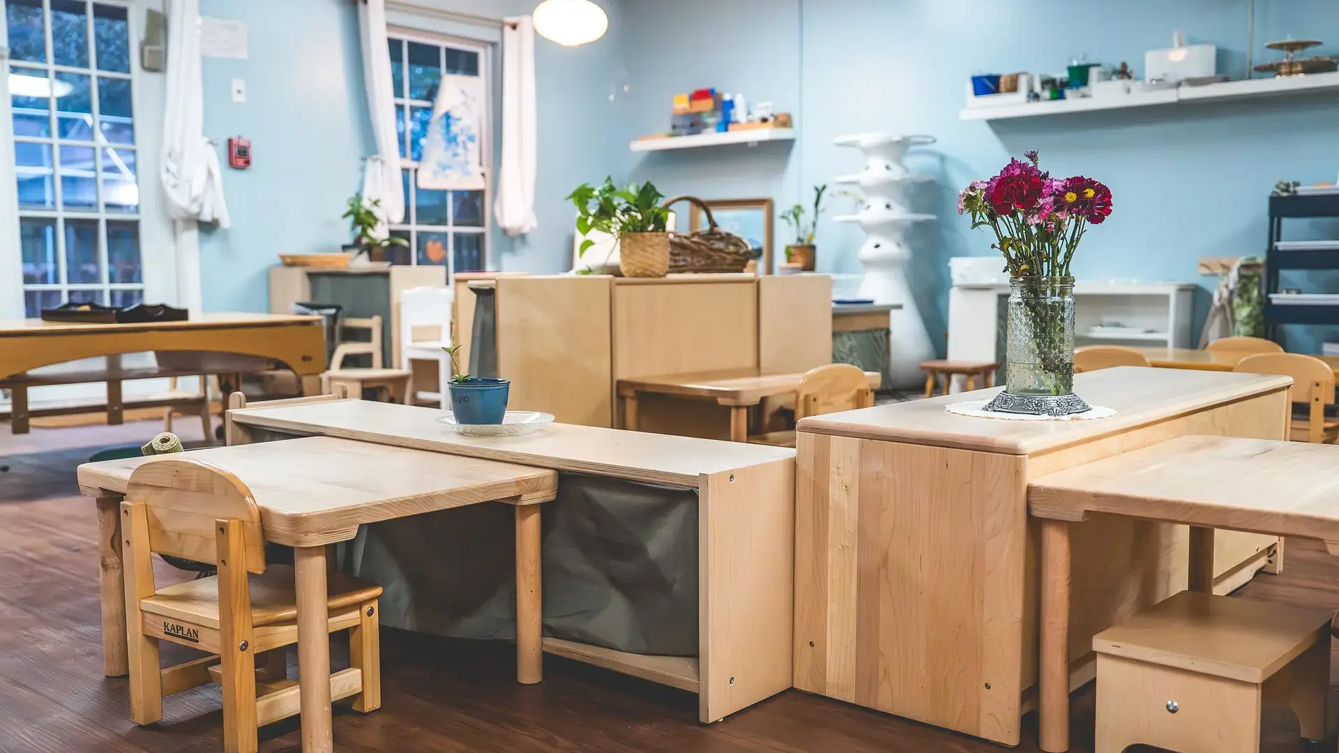 Montessori classroom with wooden tables and shelves at the Springs Campus.