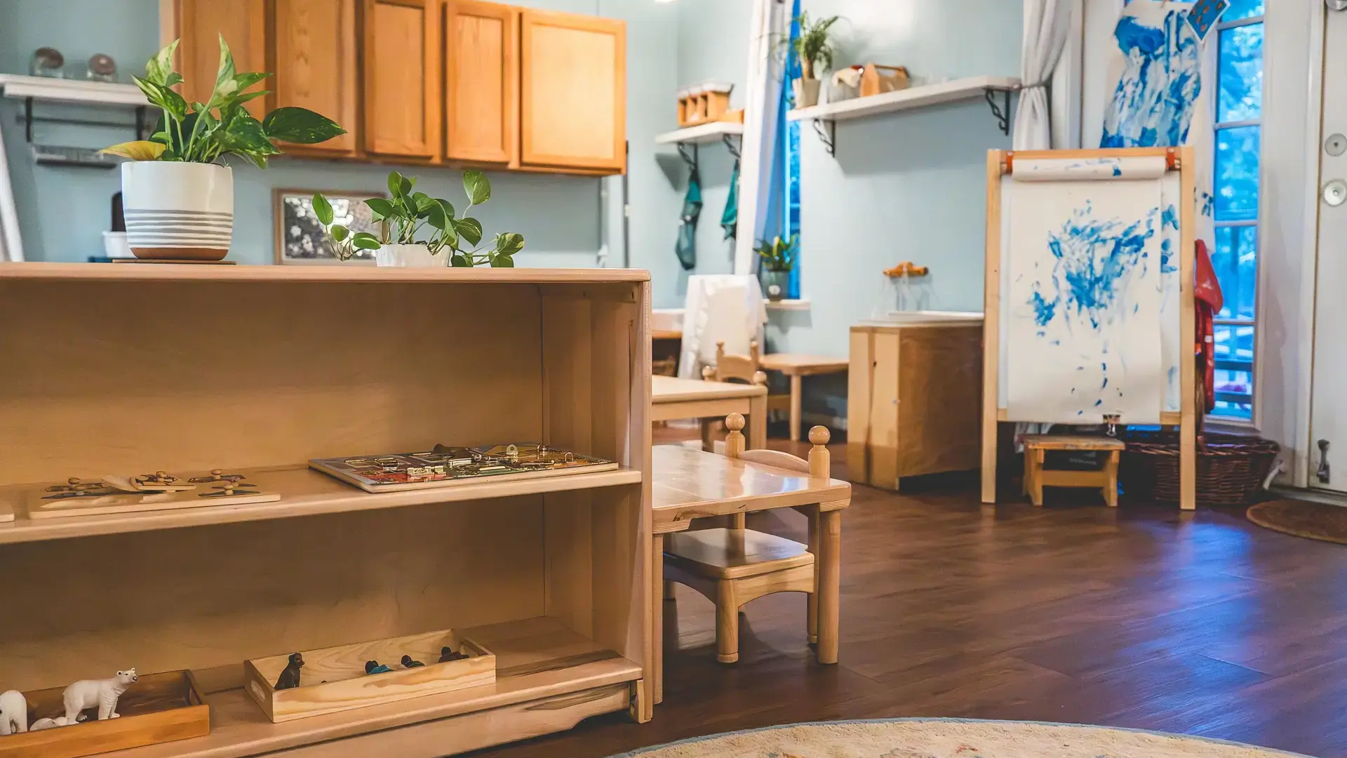 Montessori classroom with low shelves and an art easel.