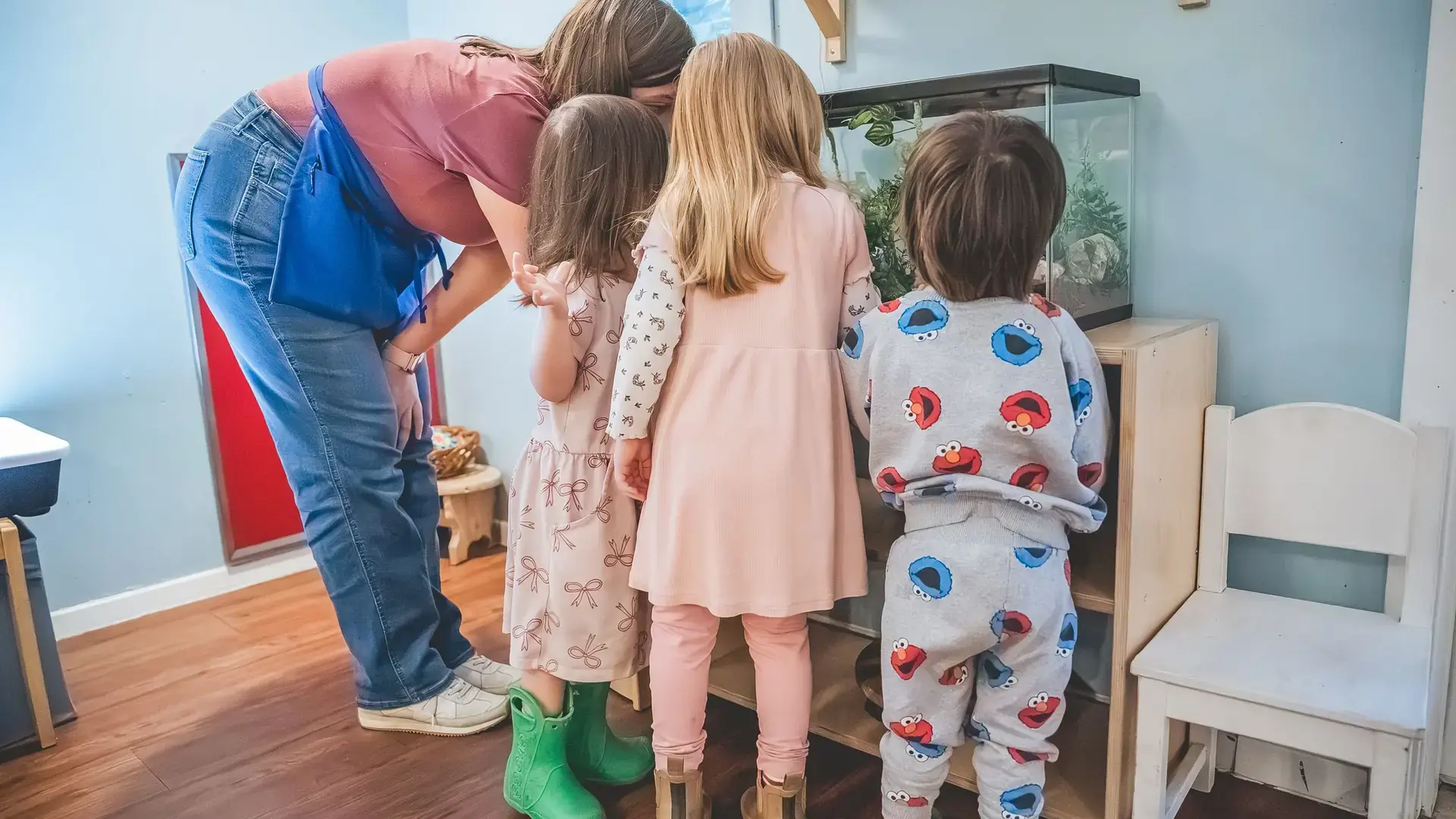 young children observing a teacher during an activity in the classroom.